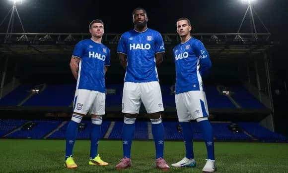 Three players in blue Ipswich Town kits on pitch