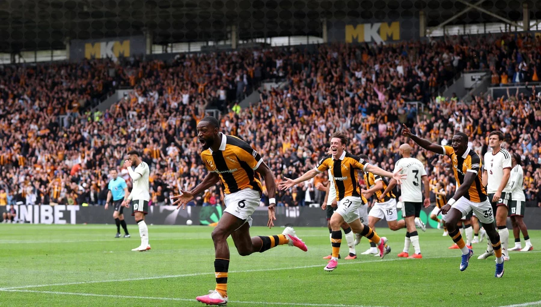 Players celebrating a goal in front of fans