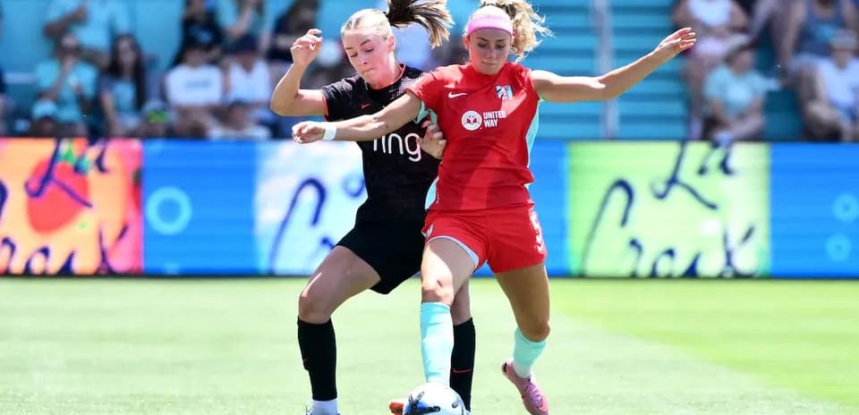 Two players competing for the ball in NWSL match