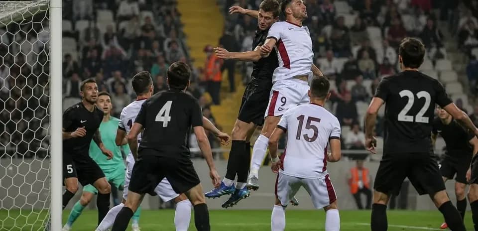 Players contesting a header near the goal area