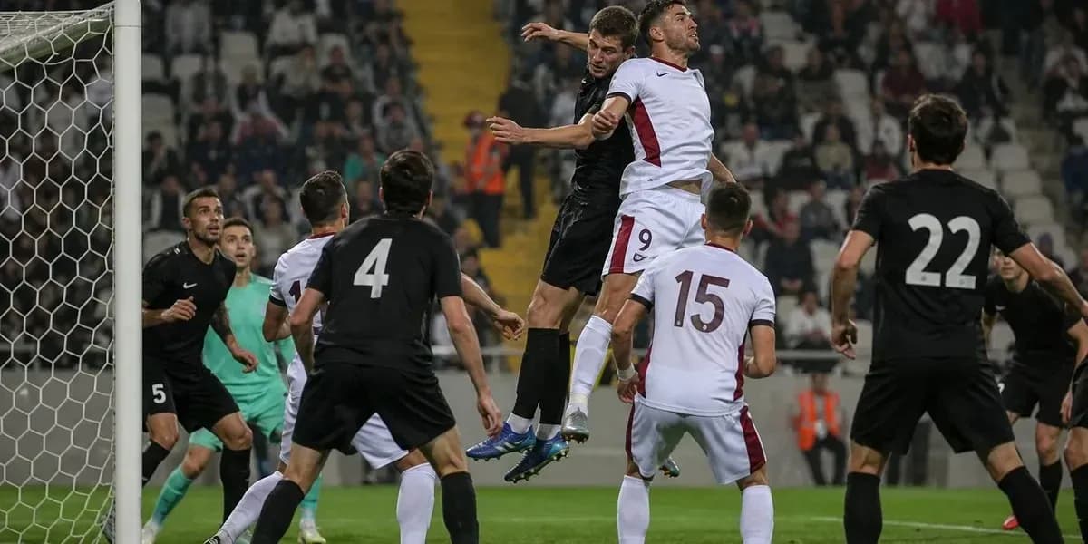Players contesting a header near the goal area