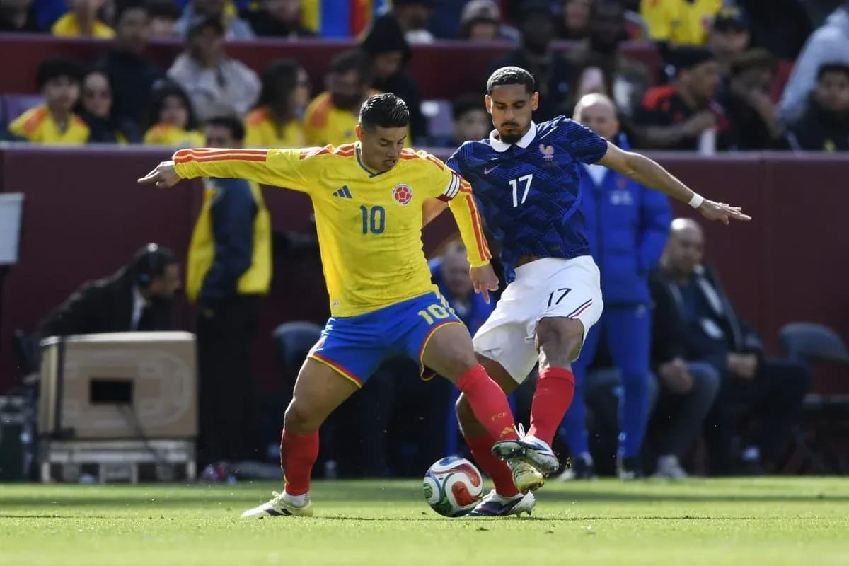 Colombian player competing for the ball against French player