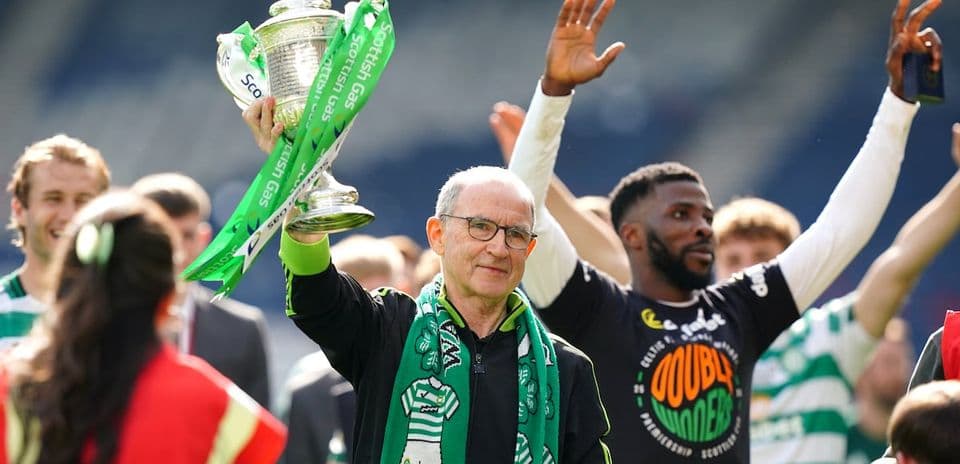 Celtic manager holding trophy with celebrating players