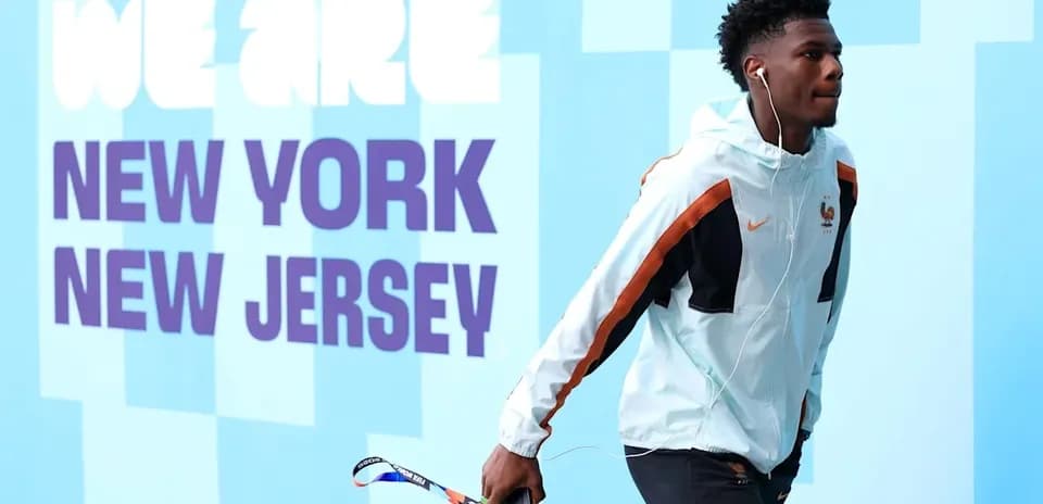 Player walking with headphones near event signage