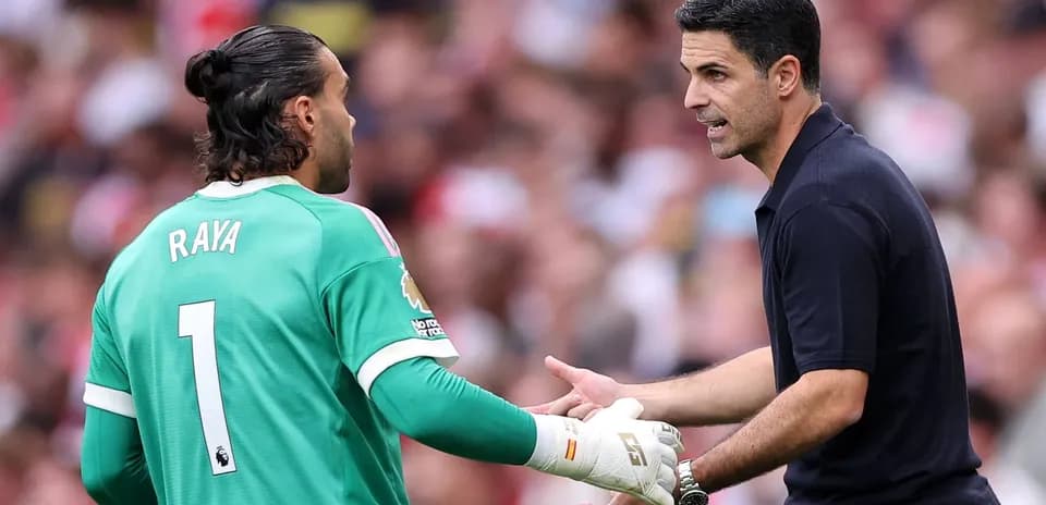 Goalkeeper and coach discussing strategy during match