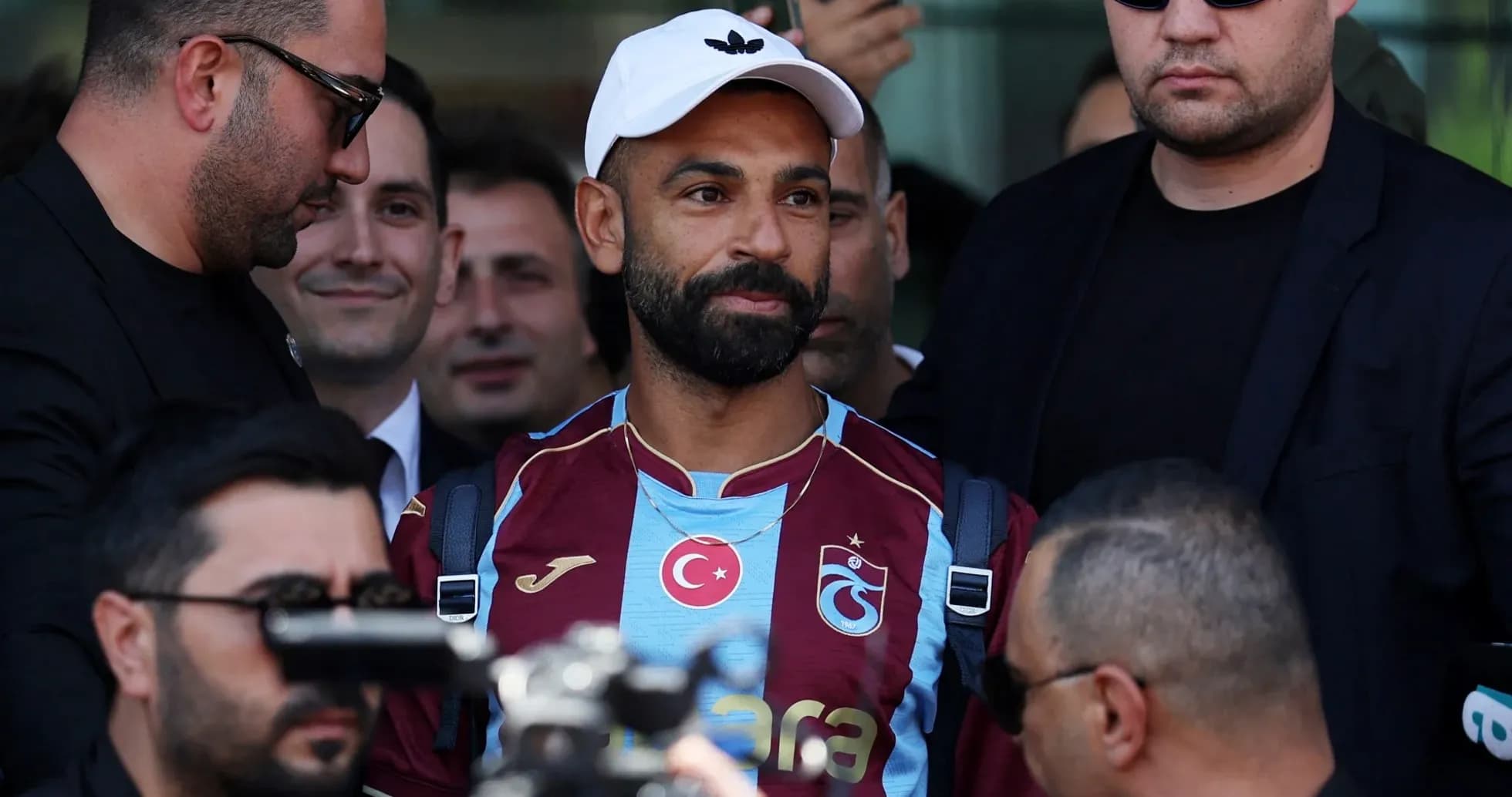 Player arriving with security at press event