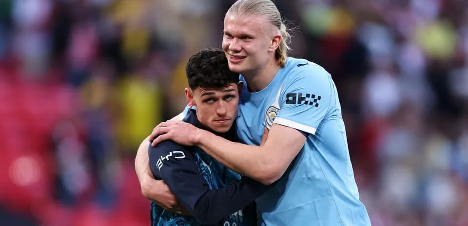 Two Manchester City players embracing on the pitch