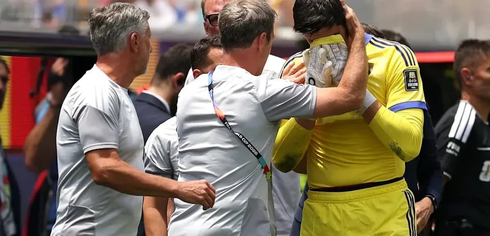 Goalkeeper receiving support from coaches on sideline