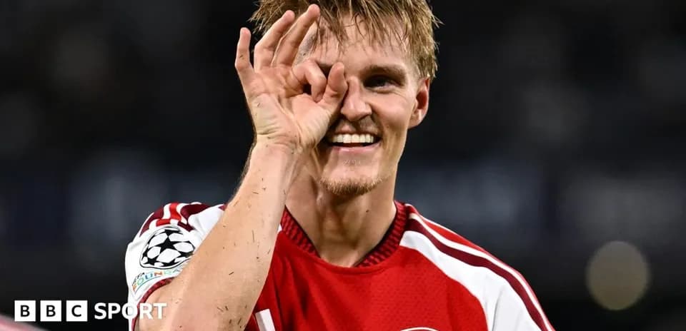Player celebrating with hand gesture in Arsenal jersey