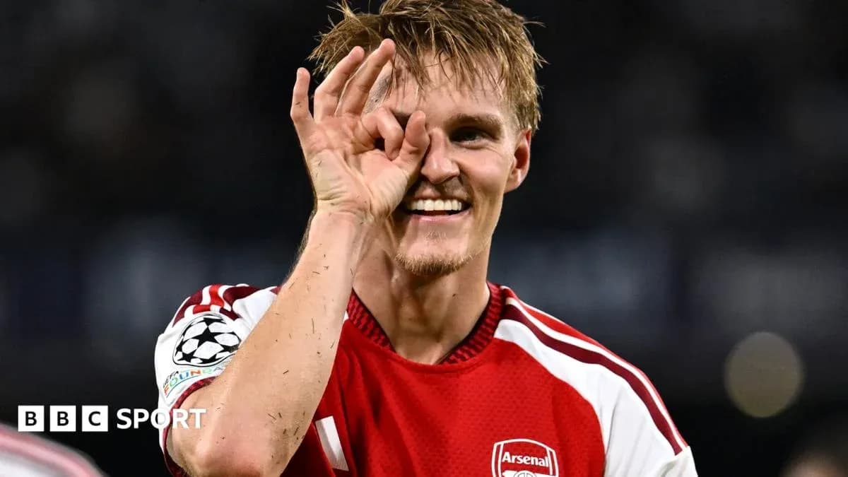 Player celebrating with hand gesture in Arsenal jersey