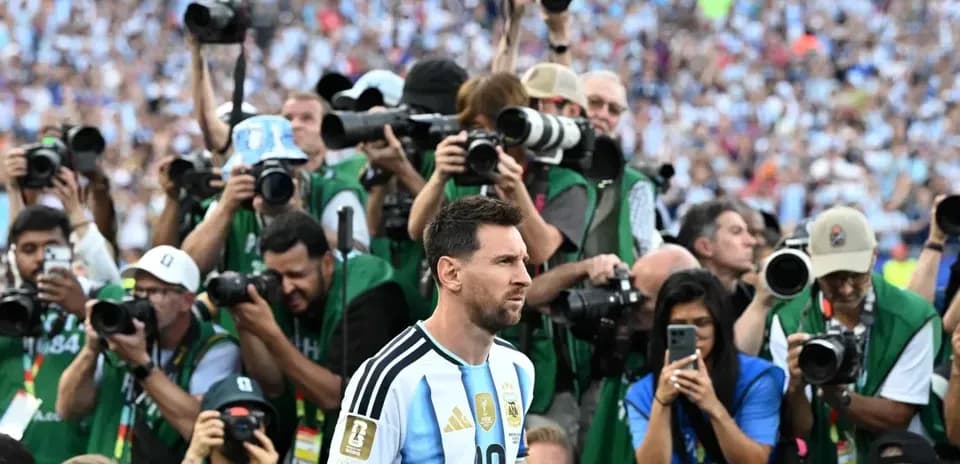 Lionel Messi surrounded by photographers on the field