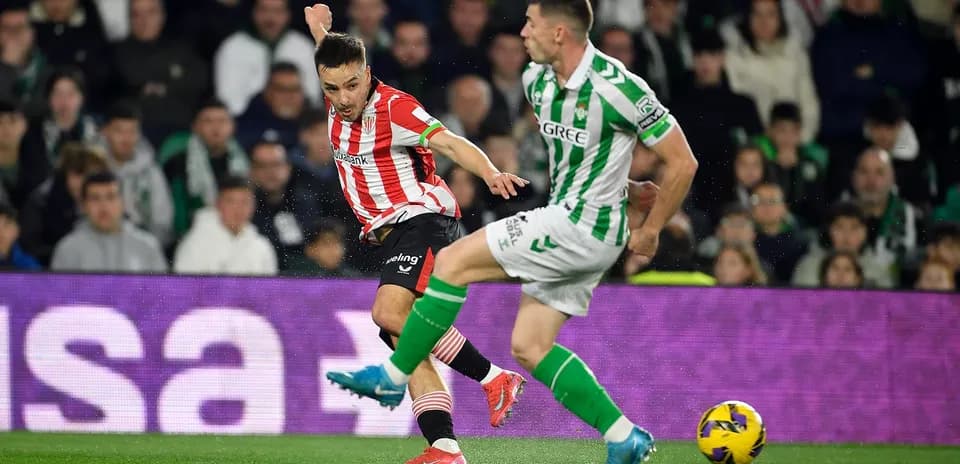 Athletic Club player dribbling past Real Betis opponent