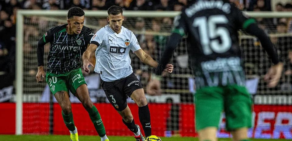Elche and Valencia players competing for the ball