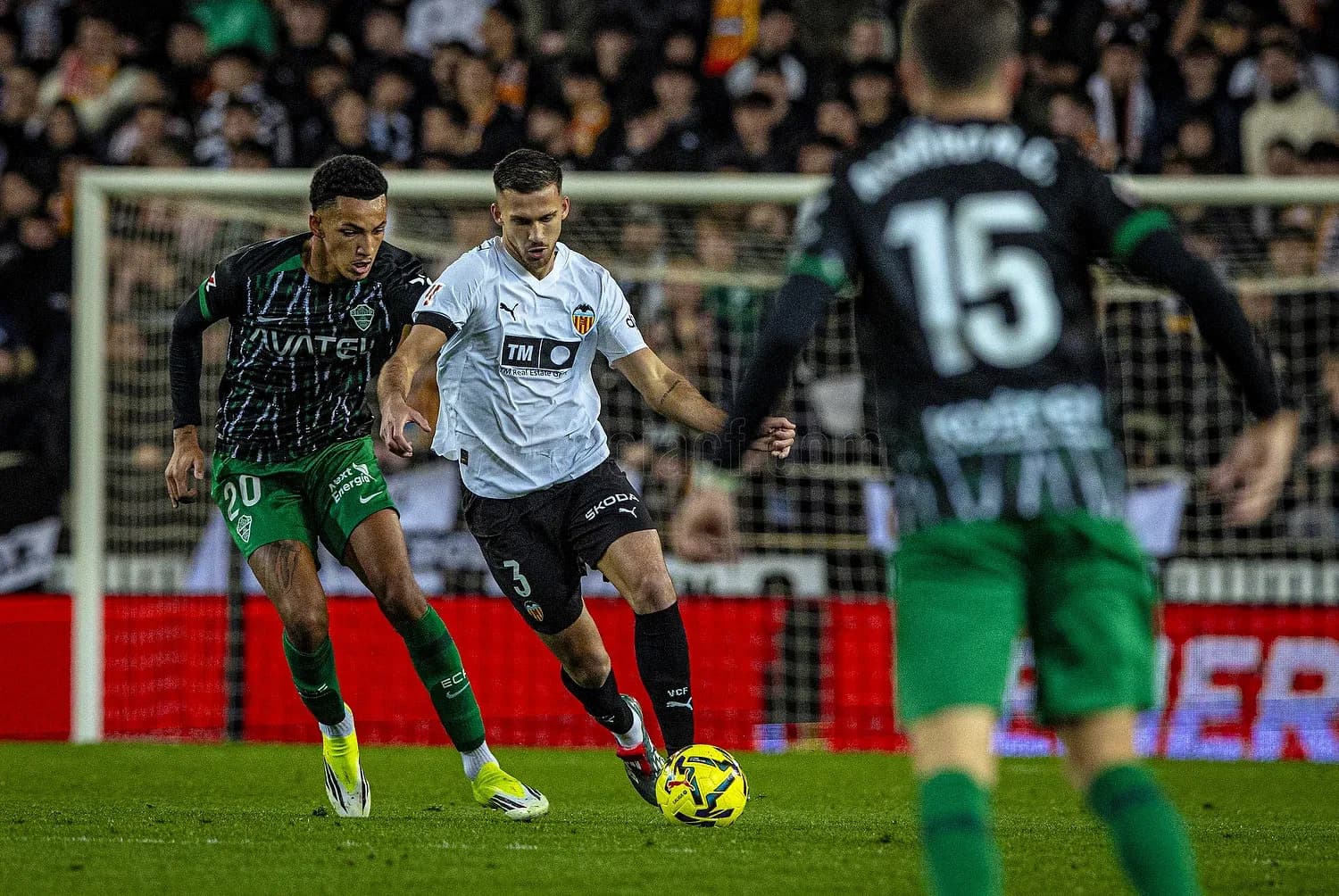 Elche and Valencia players competing for the ball