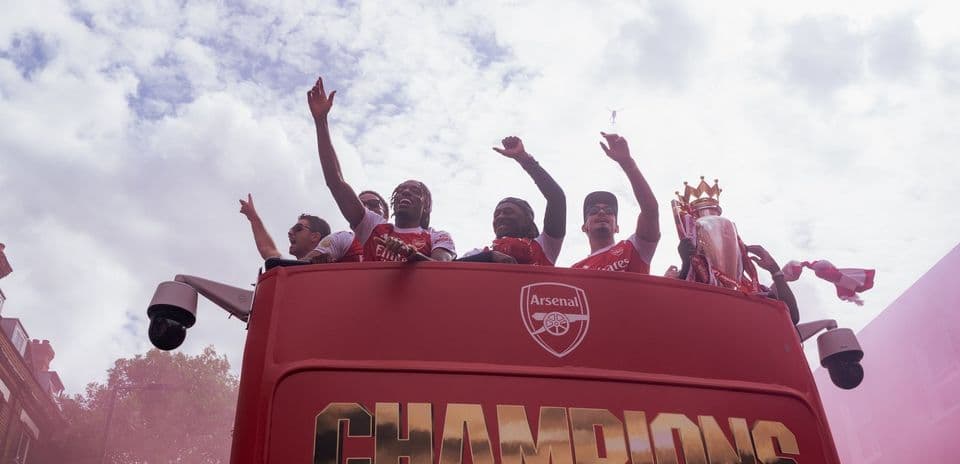 Arsenal players celebrating on victory parade bus