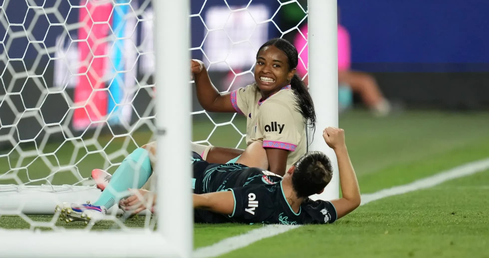 Players celebrating a goal in women's football match