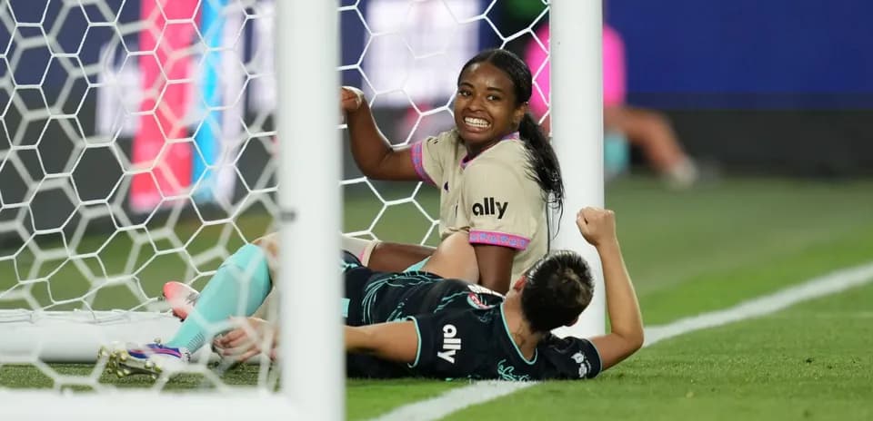 Players celebrating a goal in women's football match