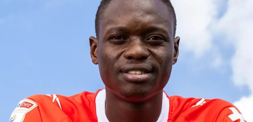Player posing in red team jersey outdoors