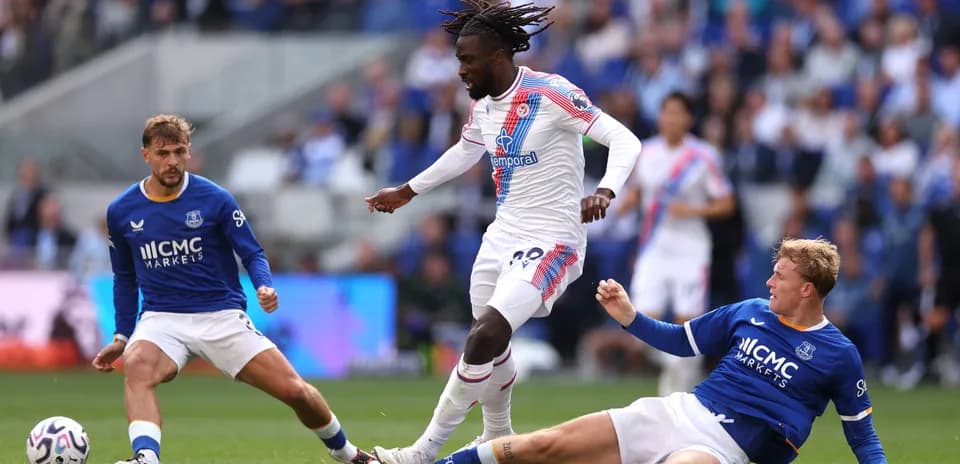 Player dribbling past two opponents during match