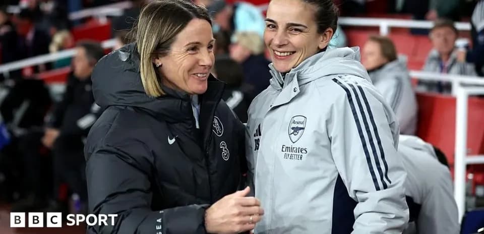 Two coaches chatting on the sidelines during match