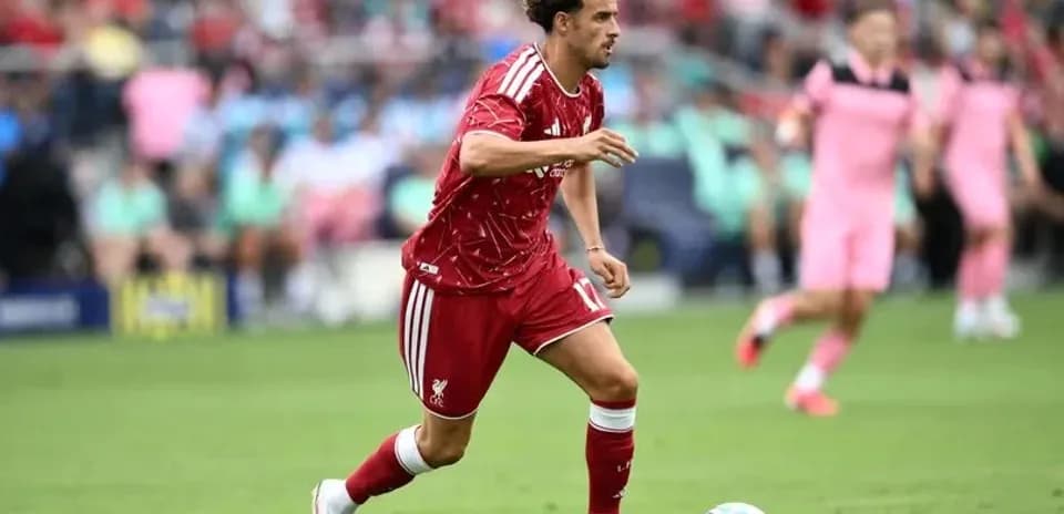 Player in red kit dribbling the ball during match