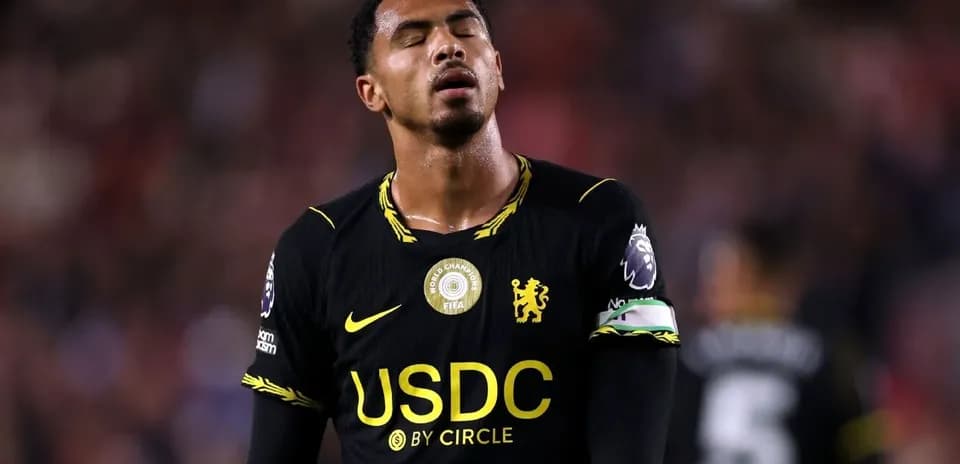 Player in black kit with captain's armband during match