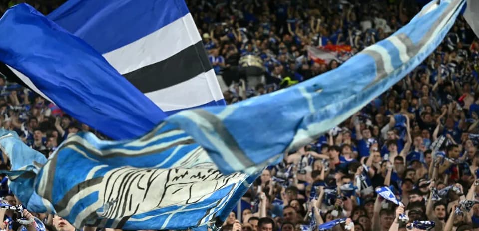 Crowd waving flags and scarves at stadium