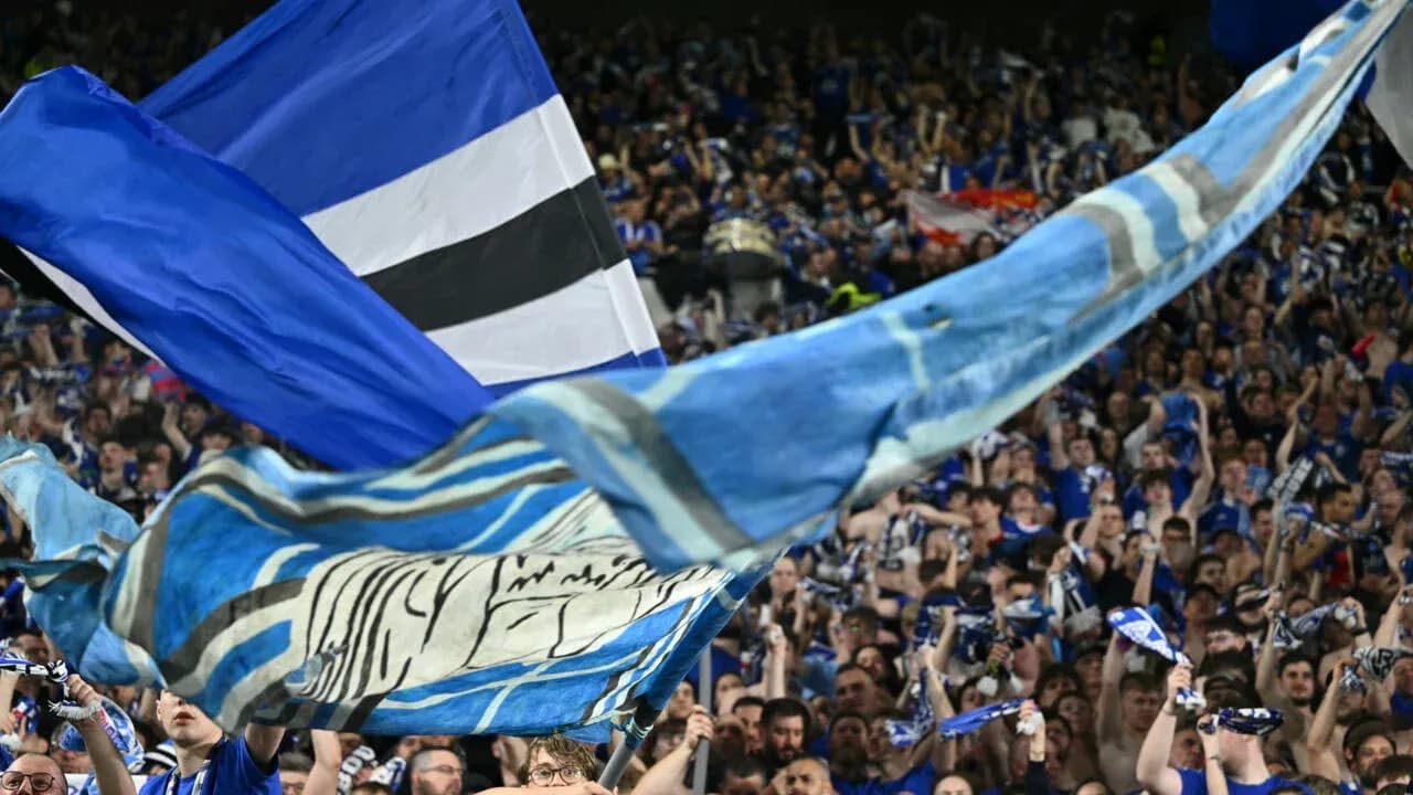 Crowd waving flags and scarves at stadium
