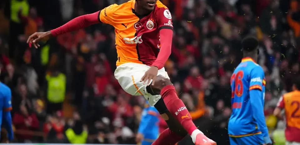 Player celebrating goal during match with fans in background