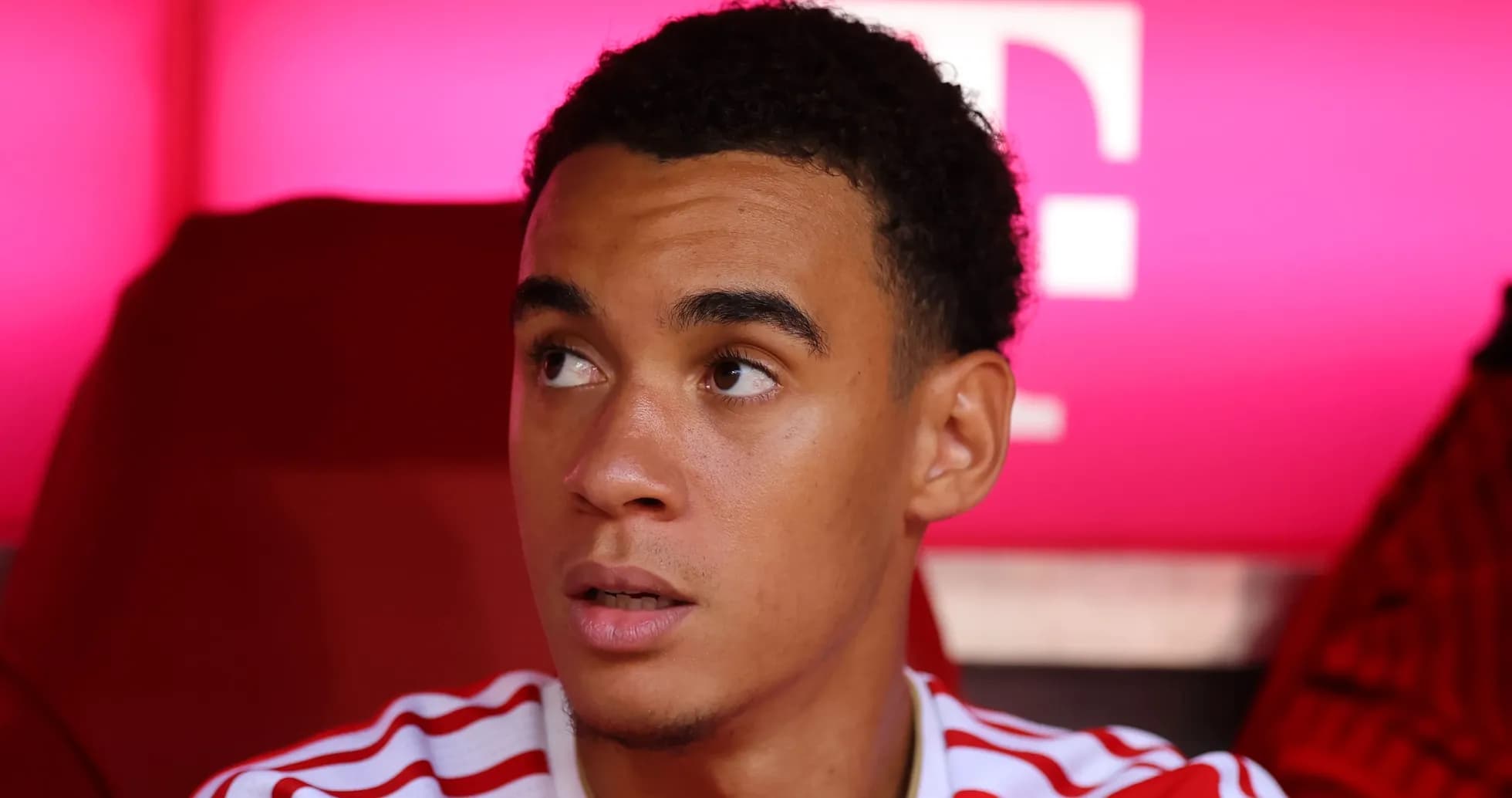 Player sitting on bench with pink background