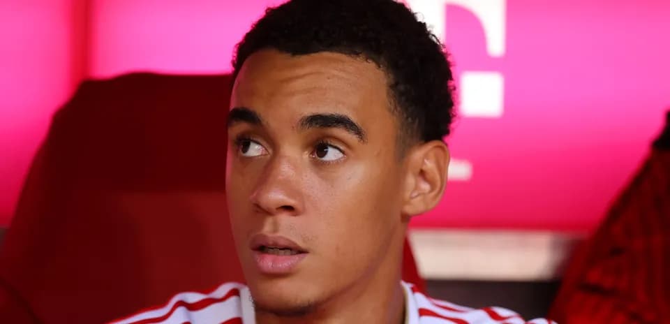 Player sitting on bench with pink background