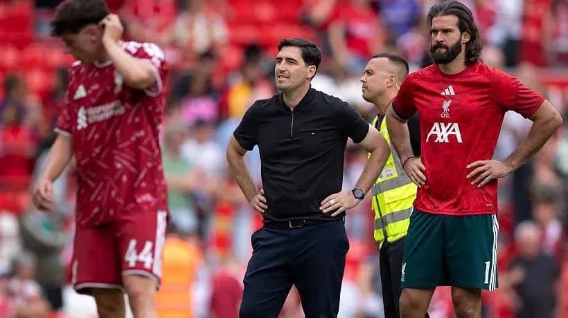 Liverpool players and coach on the pitch at Anfield
