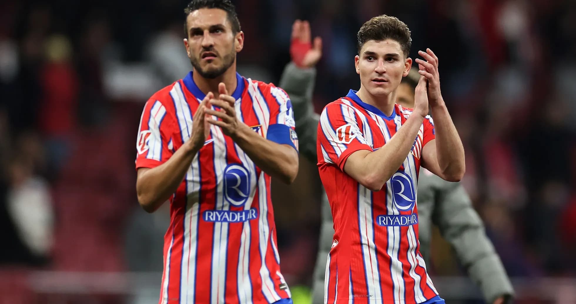 Two players applauding fans after a match