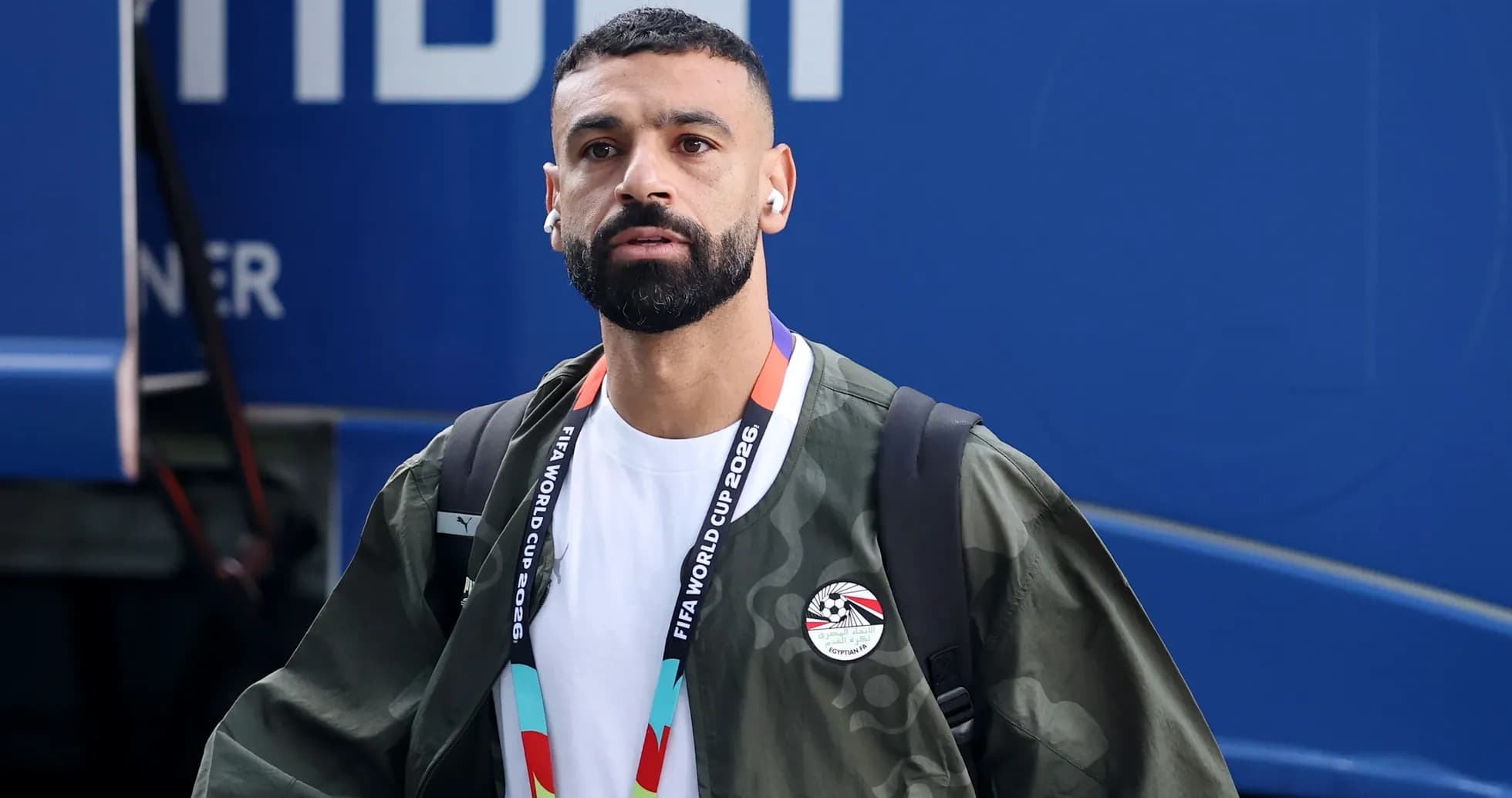 Player arriving with earbuds and FIFA credentials