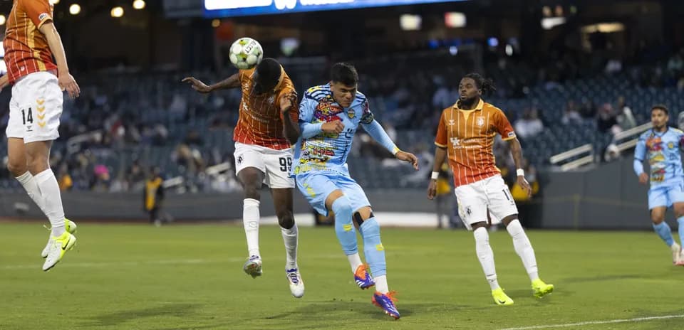 Players competing for the ball in USL Championship match