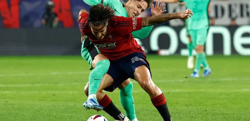 Player tackling opponent during Atletico Madrid match