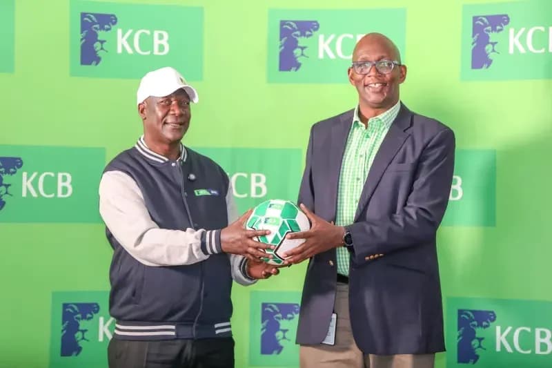 Two men holding a football at KCB event