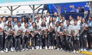 Women's sports team posing with flowers at airport