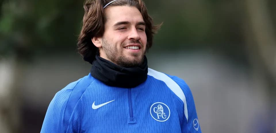 Player in blue training kit smiling outdoors