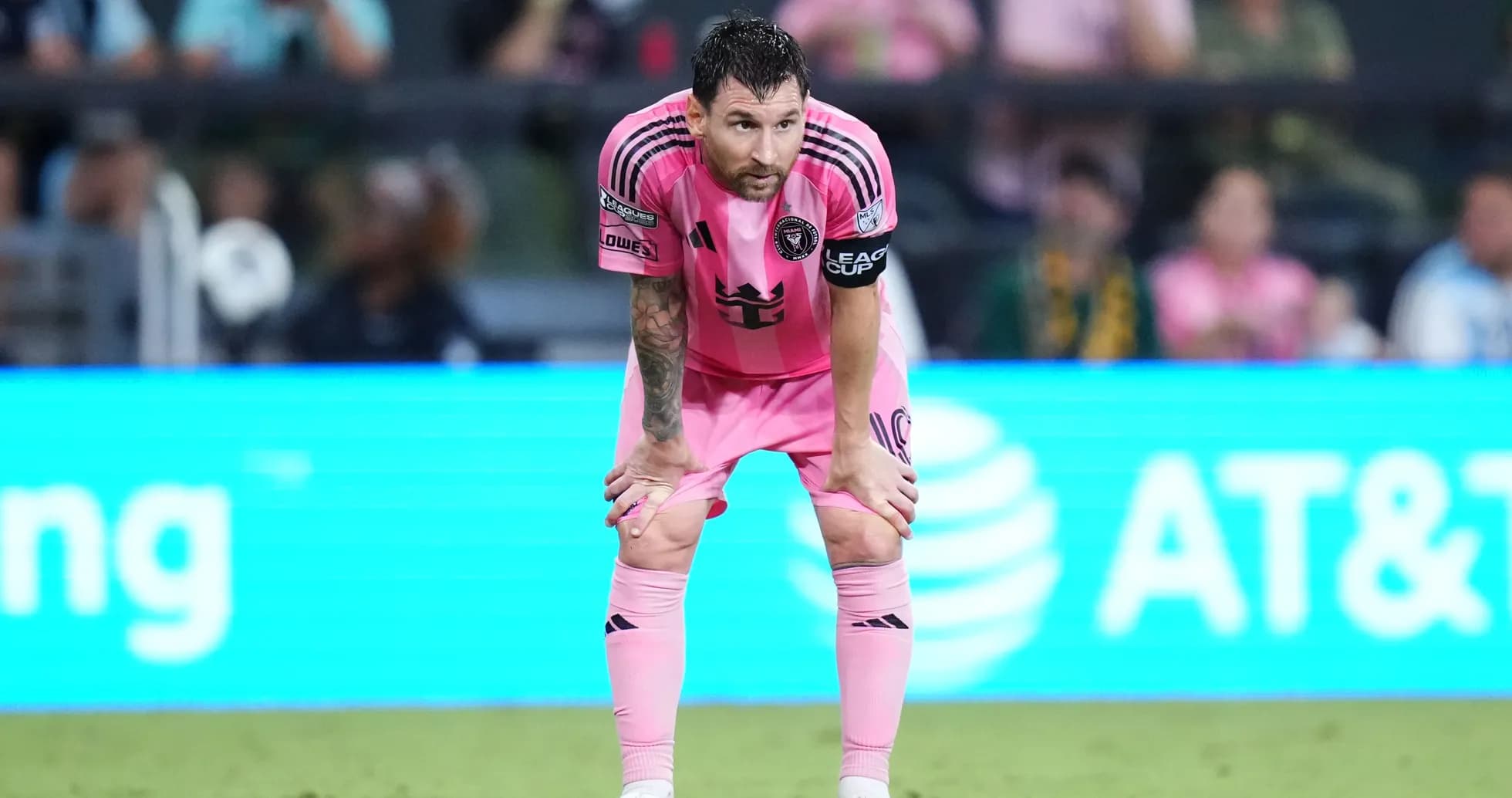 Player in pink jersey resting on knees during match