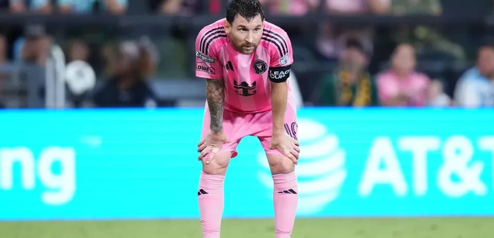 Player in pink jersey resting on knees during match