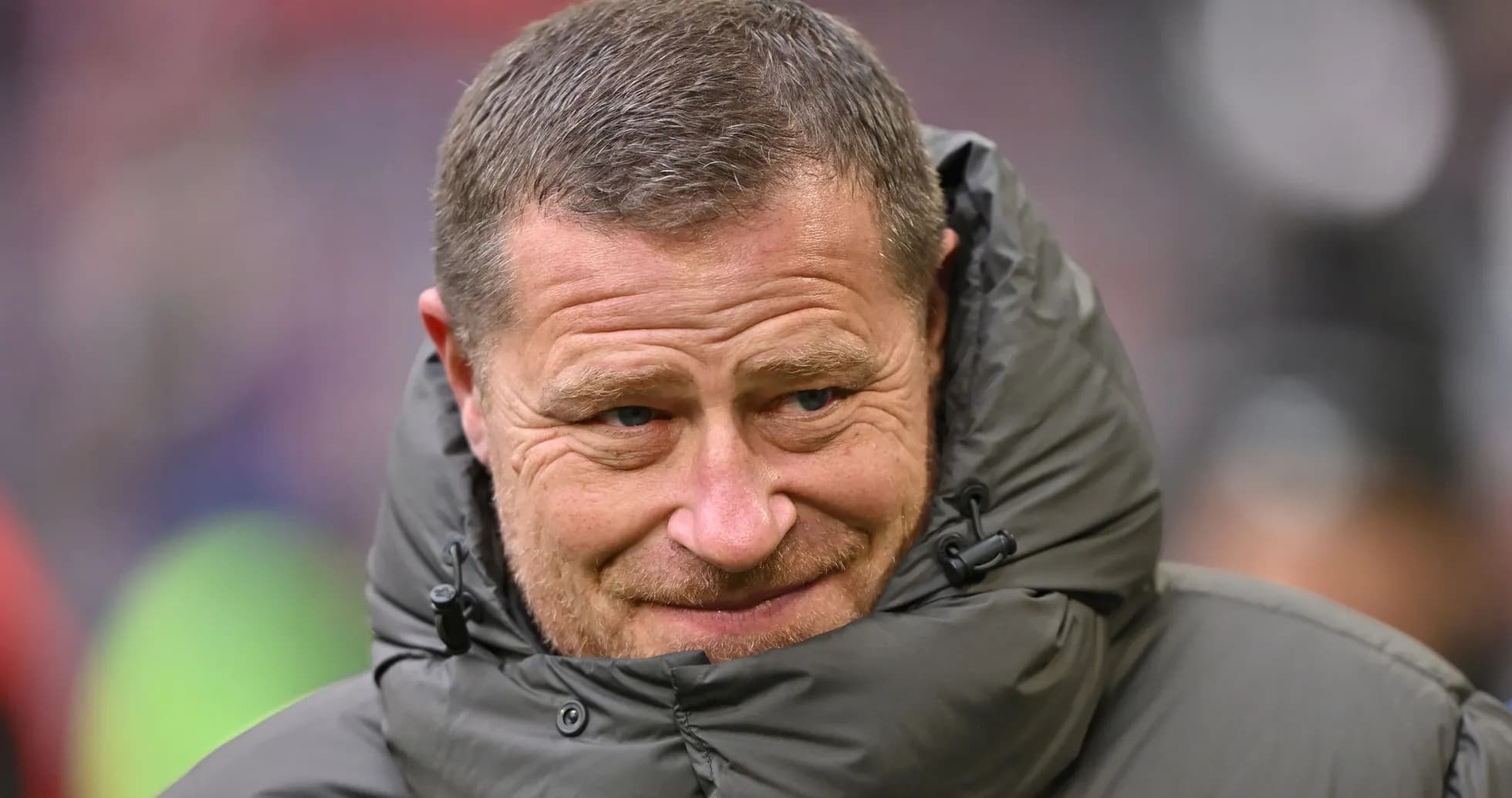 Coach wearing a padded jacket on the sidelines