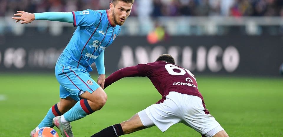 Cagliari player dribbling past Torino defender