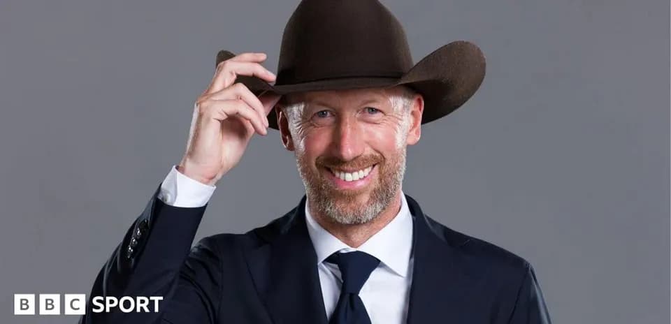 Man in a suit tipping his cowboy hat