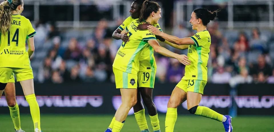 Players celebrating during NWSL match