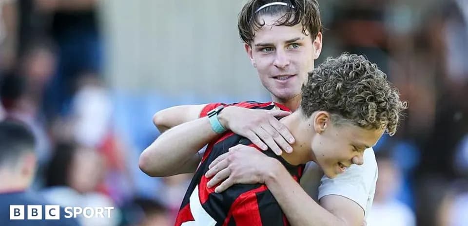 Two football players embracing on the field