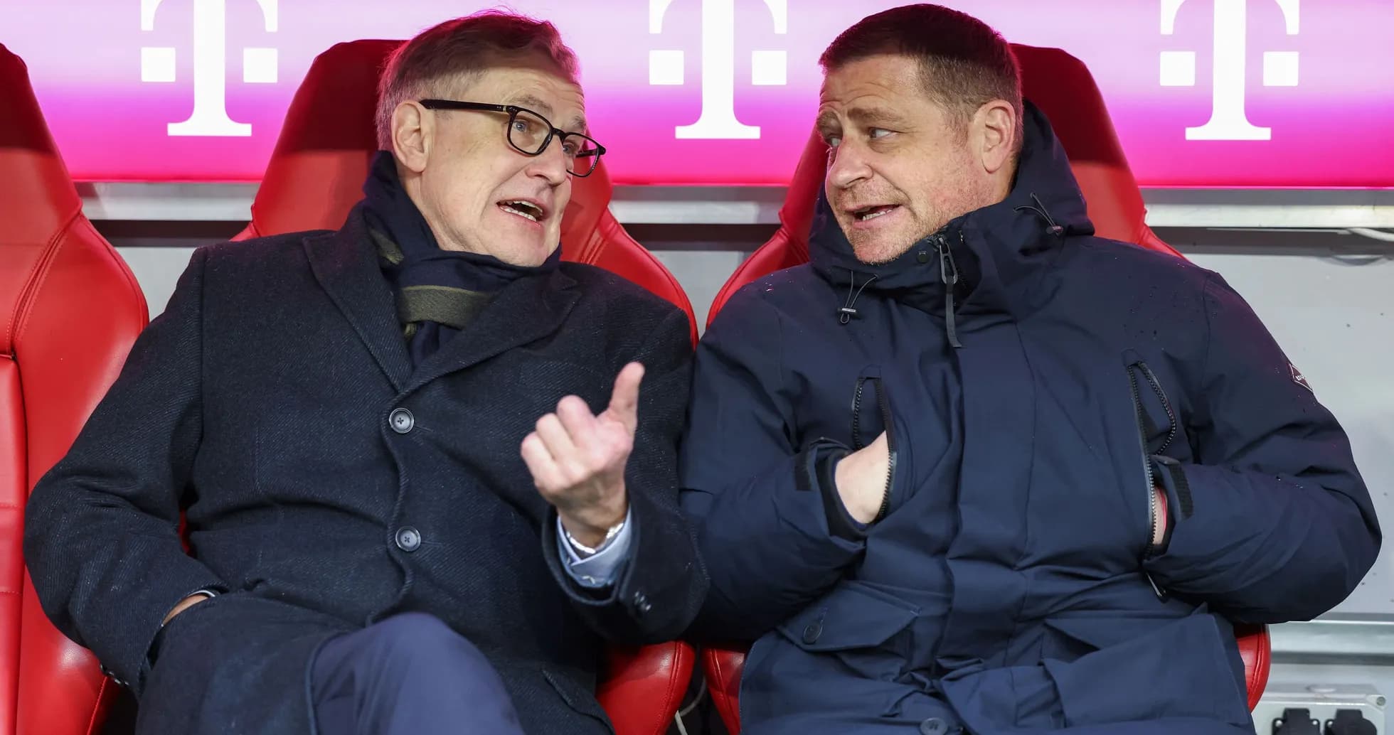 Two men conversing in team bench area