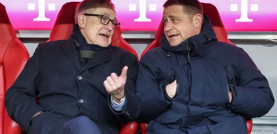 Two men conversing in team bench area