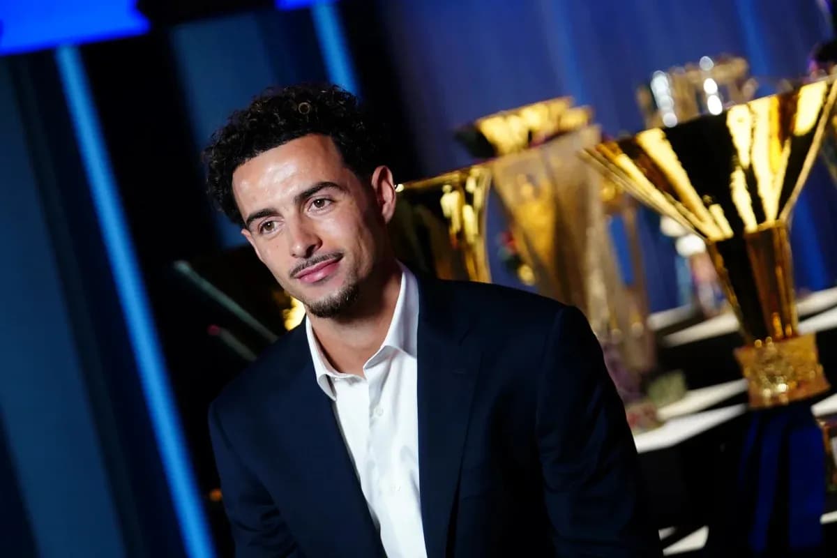 Player posing in front of multiple trophies