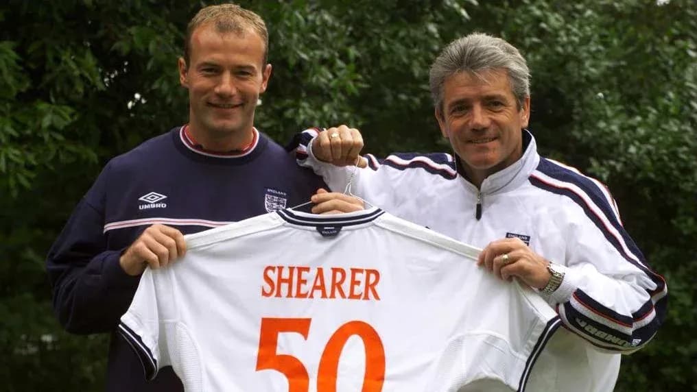 Two men holding a jersey with 'SHEARER 50'